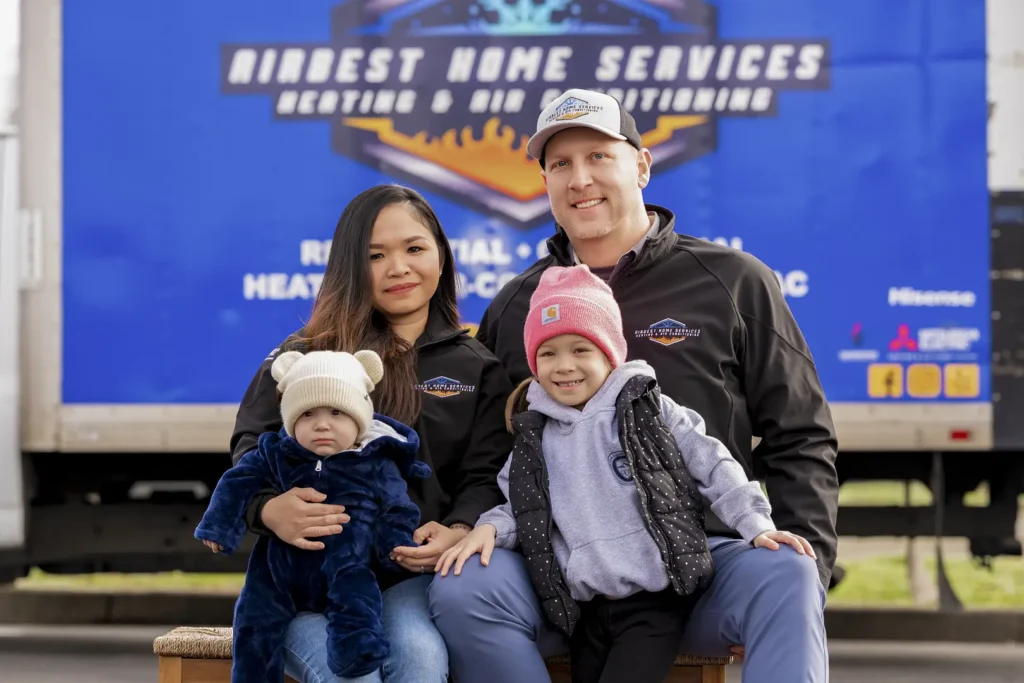 Family posing in front of truck.