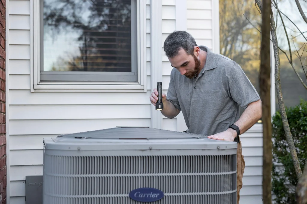 Technician inspecting outdoor air conditioning unit